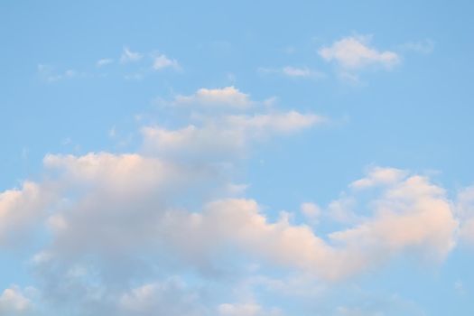 Background of blue sky with white clouds at sunset