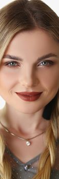 Portrait of pretty blonde woman model with braids and luxury makeup posing in studio. Young female with tricky facial expression. Emotion, modeling concept