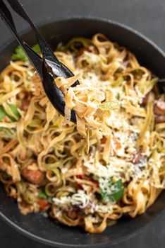 Homemade Italian fettuccini or alfredo pasta, also called Funghi Porcini cooked in a cast iron skillet with mushrooms and cream sauce. Vertical shoot