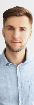 Portrait of successful young man in stylish grey shirt, presentable guy posing on white background. Confident man pose for picture. Success, status concept