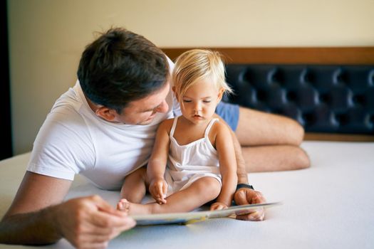 Dad teaching little daughter to read. High quality photo