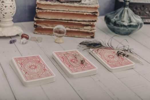 Black candle and old tarot cards on wooden planks. Halloween and fortune telling concept. Mystic background with occult and magic objects on witch table