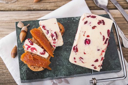 A closeup shot of Wensleydale cheese with cranberries and wine