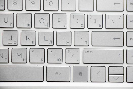 Laptop and notebook computer keyboard close-up, texts, keys and gray board.