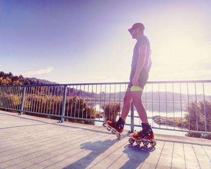 Doksy range, Czech Republic, 9th of October 2018. Roller skater ride in park. Boy legs in in-line hard shell boots blades.