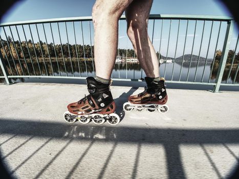 Doksy range, Czech Republic, 9th of October 2018.  Man roller skater in speed hard shell skates. Man try trick on the pathway against the sun