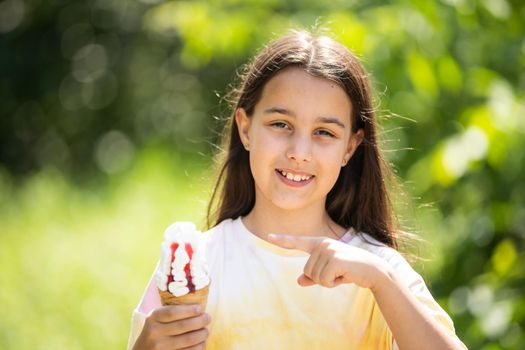 Pretty little girl eating an ice cream outdoors