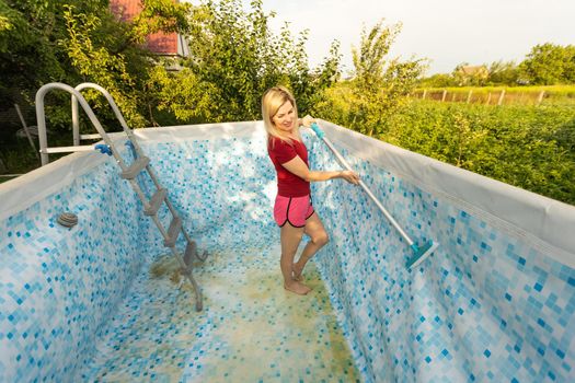 woman cleaning the pool in the garden.