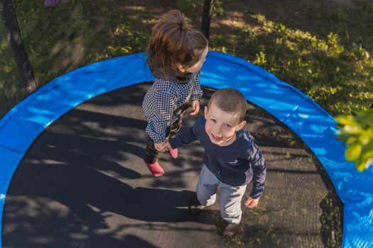top view of small children jumping on a trampoline
