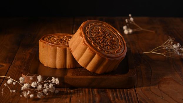Round shaped Chinese traditional mooncakes on wooden background. Mid Autumn festival and Chinese traditional festival.