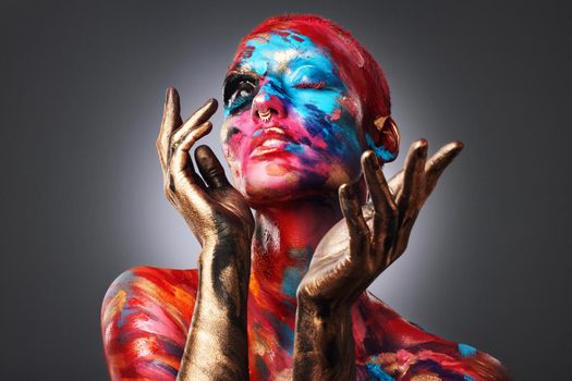 I dont want to be average. an attractive young woman posing alone in the studio with paint on her face and body