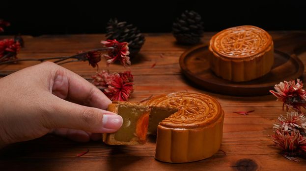 Delicious traditional moon cake on wooden table, for Chinese Mid Autumn Festival celebration.