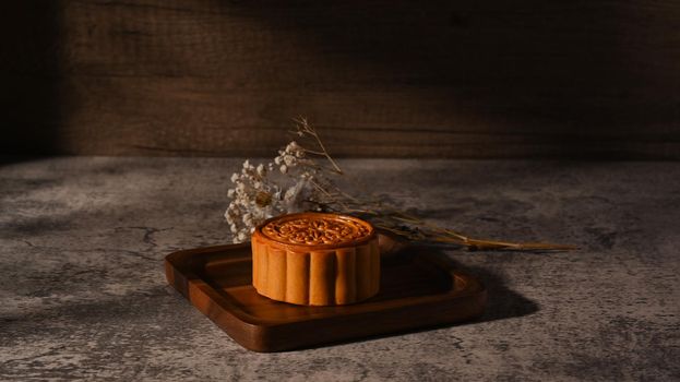 Delicious traditional mooncake on wooden tray. Mid Autumn festival and Chinese traditional dessert.