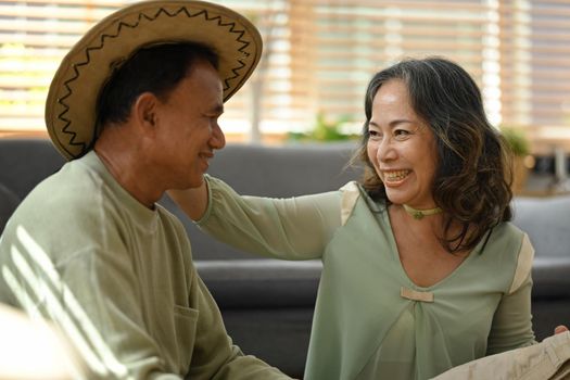 Happy senior couple packing cloth and stuff, getting ready for summer vacation. Traveling in retirement concept.