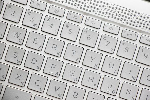 Laptop and notebook computer keyboard close-up, texts, keys and gray board.