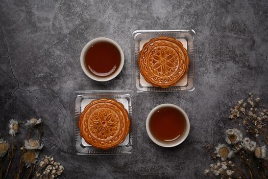 Flat lay Chinese traditional mid autumn festival moon cake on grey rustic background.