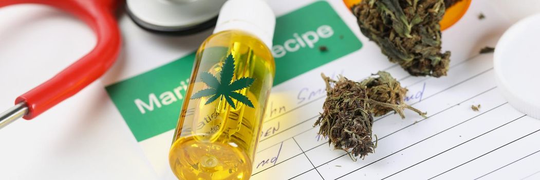 Close-up of jar with dried marijuana scattered on patient medical prescription. Medication for patient, stethoscope equipment. Alternative medicine concept