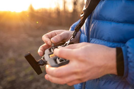 Person hands holding remote controller for quadcopter drone helicopter. Digital radio device technology for professional aerial video shooting
