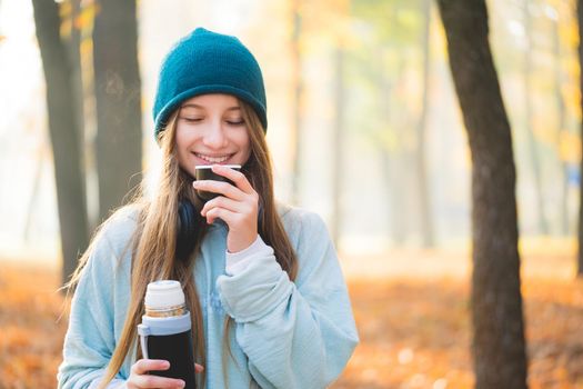 Sweet girl drinking tea in autumn nature