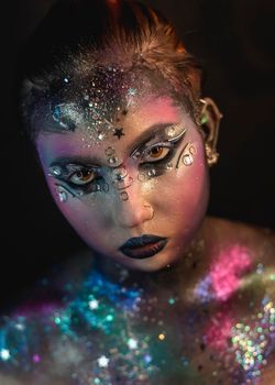 Portrait of young female model with creative makeup,  rhinestones and piercing