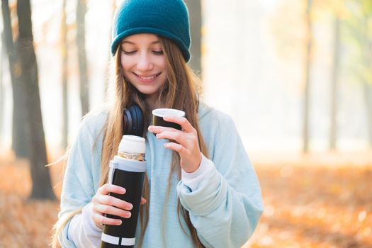 Sweet girl drinking tea in autumn nature