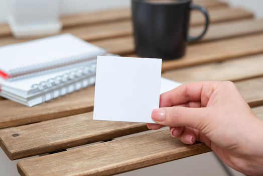 Woman Holding Important Message On Paper On Table With Coffee And Notebooks