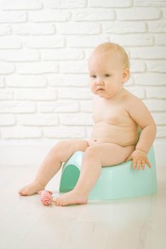 Cute baby training to piss into pot