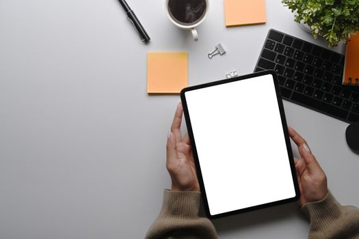 Above view businesswoman using digital table at her office desk.