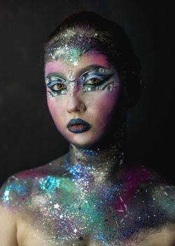 Portrait of young female model with creative makeup,  rhinestones and piercing