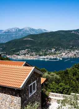 Kotor town and bay view from above in Montenegro with red roofs houses in the foreground. Scenic panorama on Adriatic sea and mountains