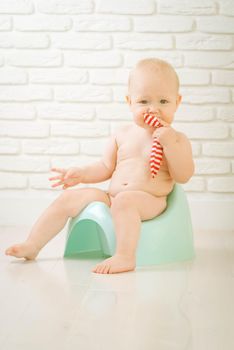 Cute baby training to piss into pot