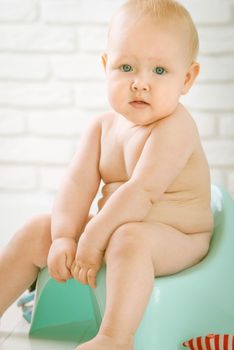 Cute baby training to piss into pot