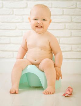 Cute baby training to piss into pot