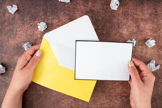 Woman Holding Blank Letter With Envelope Surrounded With Crumpled Papers.