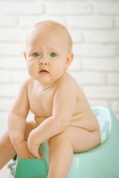 Cute baby training to piss into pot