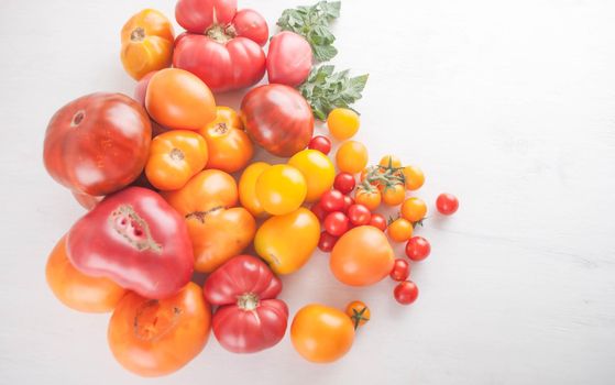 variation of fresh ripe tomatoes on wooden background