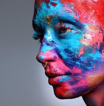 Art is what you see and feel. an attractive young woman posing alone in the studio with paint on her face
