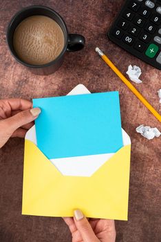 Woman Holding Blank Letter With Coffee And Stationery Over Wood.