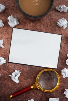 Blank Sheet With Crumpled Papers, Magnifying Glass And Coffee Cup.