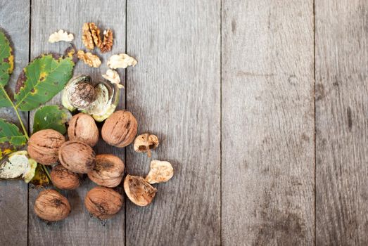walnut on wooden background with leaves and nutshell crached