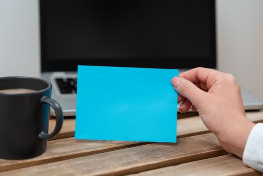 Woman Holding Note With Important Ideas On Table With Lap Top And Coffee.