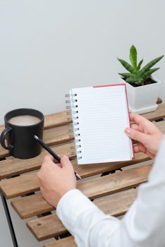 Woman Holding Pen And Notebook With Important Message On Table.