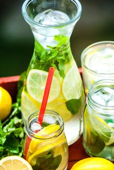 fresh homemade lemonade in pincher and jar of green bluered background