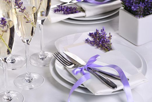 Lavender mood. Dining table in Provence style, with Lavender Champagne, folded napkin with cutlery, decorated with fresh lavender. Detail of the wedding dinner. Wedding theme ideas.