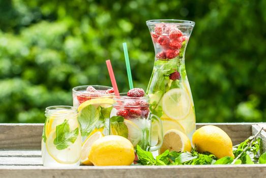 fresh homemade lemonade in pincher and jar of green bluered background