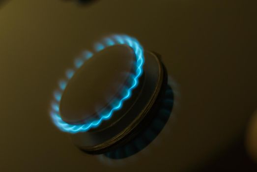 abstract gas burner with blue flame on dark background