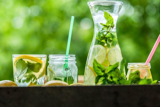 fresh homemade lemonade in pincher and jar of green bluered background