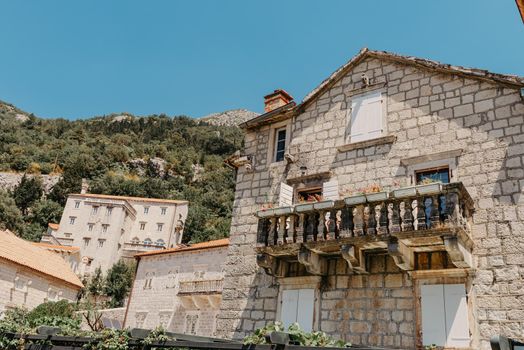 Historic city of Perast at Bay of Kotor in summer, Montenegro. Scenic panorama view of the historic town of Perast at famous Bay of Kotor with blooming flowers on a beautiful sunny day with blue sky and clouds in summer, Montenegro, southern Europe