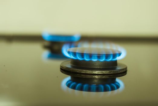 abstract gas burner with blue flame on dark background