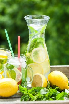 fresh homemade lemonade in pincher and jar of green bluered background